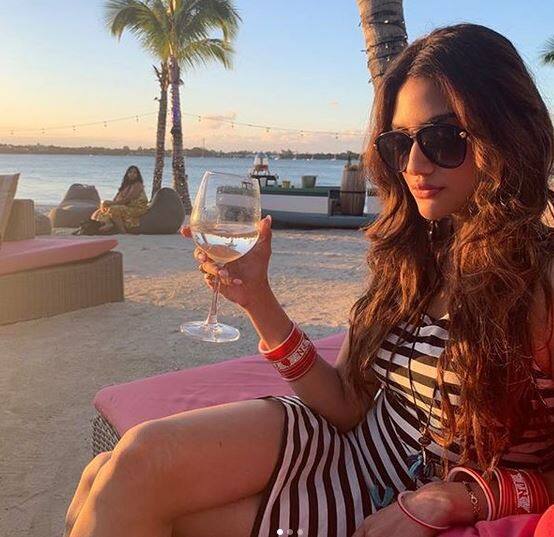 આ તસવીરમાં નુસરત કોઇ બીચ પર પોઝ આપતી નજરે પડે છે. આ ફોટામાં તે વન પીસ પહેરેલી નજરે પડી રહી છે. ફોટો પડાવતી વખતે તેના હાથમાં વાઇન ગ્લાસ પણ જોવા મળે છે.