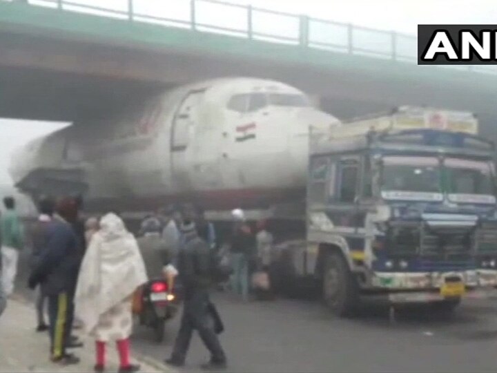 A truck carrying an abandoned India Post aircraft has got stuck under a bridge in Durgapur at West Bengal પશ્ચિમ બંગાળમાં બ્રિજ નીચે આખે આખું પ્લેન ફસાઈ ગયું ને પછી.....