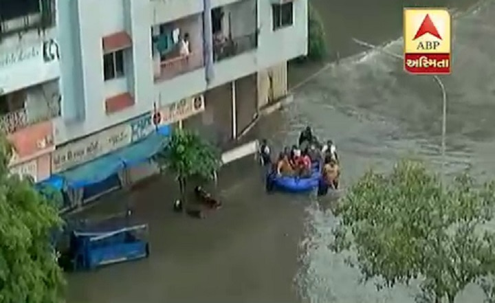 Surat flood : RSS and Councillor Vijay Chomal help to people in flood situation  ખાડીમાં પૂરથી સુરતનાં અનેક વિસ્તારો બેટમાં ફેરવાયા, હાલ આવી છે સ્થિતિ, તસવીરોમાં જુઓ દ્રશ્યો